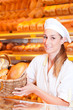 Female baker selling bread in her bakery