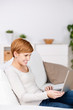 Photo: junge frau sitzt mit laptop auf dem sofa junge frau sitzt mit laptop auf dem sofa