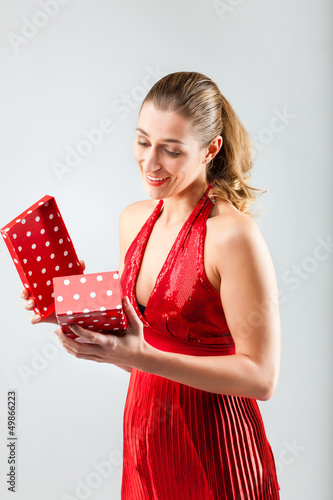 Photo: Woman opening the gift and is happy Woman opening the gift and is happy