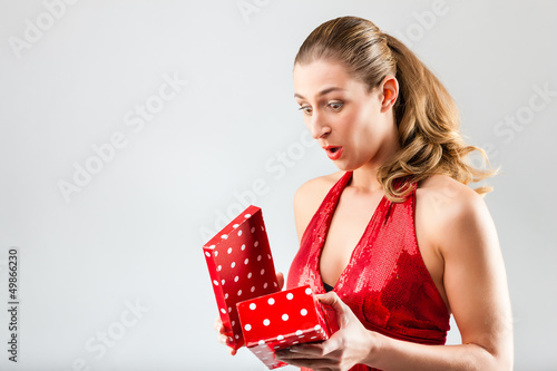 Photo: Woman opening the gift and is happy Woman opening the gift and is happy