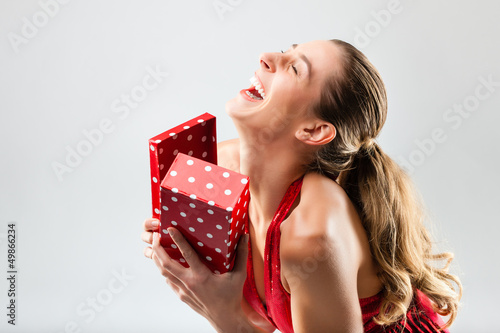 Photo: Woman opening the gift and is happy Woman opening the gift and is happy