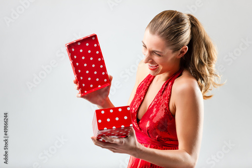 Photo: Woman opening the gift and is happy Woman opening the gift and is happy