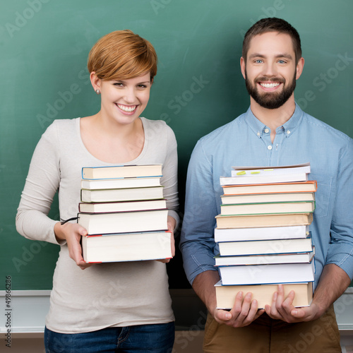 Photo: zwei studenten tragen schwere bücher zwei studenten tragen schwere bücher