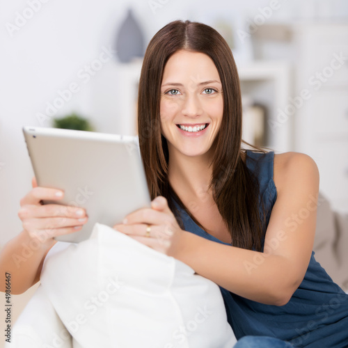 Photo: entspannte frau liest zuhause am tablet entspannte frau liest zuhause am tablet