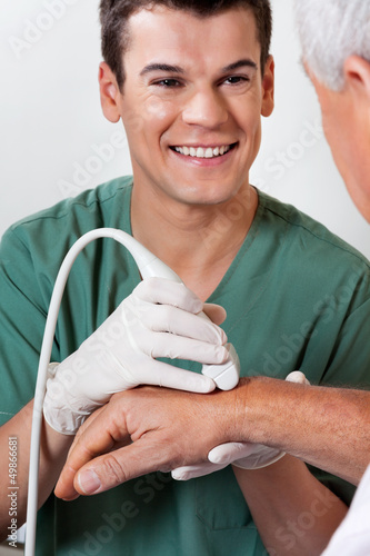 Photo: Technician Scanning Male Patient's Hand Technician Scanning Male Patient's Hand