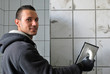 Junger freundlicher Fliesenleger bei der Arbeit