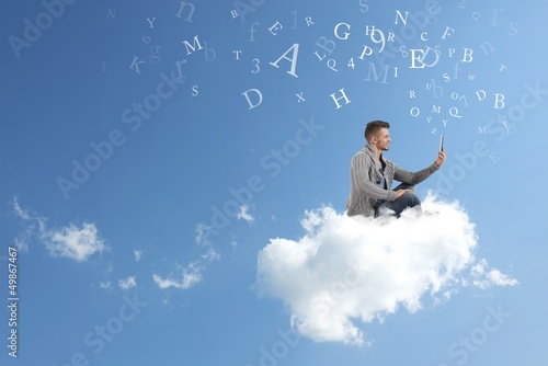 Photo: Businessman works over a cloud Businessman works over a cloud