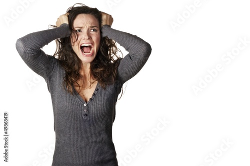 Photo: Frustrated and angry woman is screaming and pulling her hair Frustrated and angry woman is screaming and pulling her hair