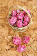 Photo: Small pick roses in a handmade straw basket on a wooden table Small pick roses in a handmade straw basket on a wooden table