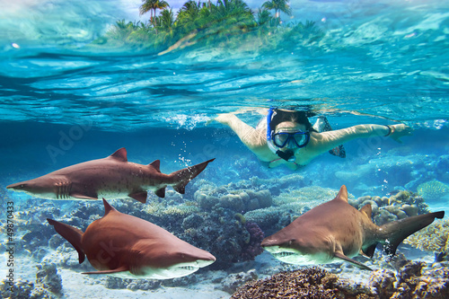Photo: Woment snorkeling in the tropical water with dangerous sharks Woment snorkeling in the tropical water with dangerous sharks