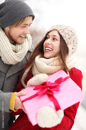 Photo: Man surprising woman with gift Man surprising woman with gift