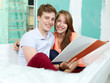 Foto: Young couple checking the plans of their building lot Young couple checking the plans of their building lot
