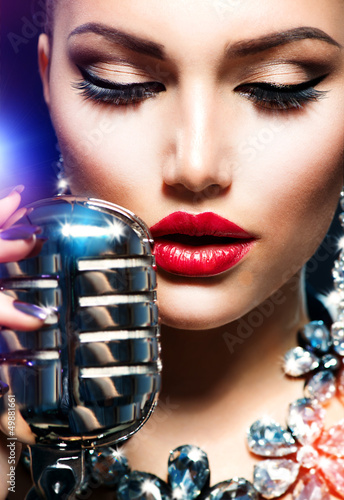 Photo: Singing Woman with Retro Microphone. Vintage Style Singing Woman with Retro Microphone. Vintage Style