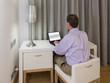 Man at white desk and chairs in hotel