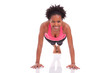 Young beautiful african fitness woman doing push up exercises on