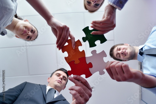 Photo: Group of business people assembling jigsaw puzzle Group of business people assembling jigsaw puzzle