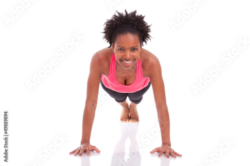 Photo: Young beautiful african fitness woman doing push up exercises on Young beautiful african fitness woman doing push up exercises on