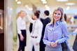 business woman with her staff in background at office