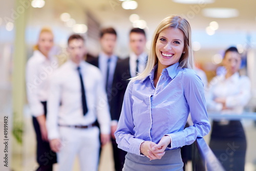 Photo: business woman with her staff in background at office business woman with her staff in background at office