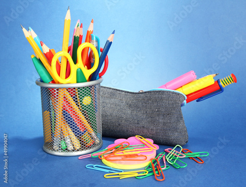 Photo: pencil box with school equipment on blue background pencil box with school equipment on blue background