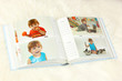 Open photo album with pictures on white carpet