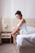 Smiling brunette sitting on hotel bed