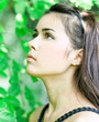 Portrait of beautiful cute young girl yearning in leafage outdoo