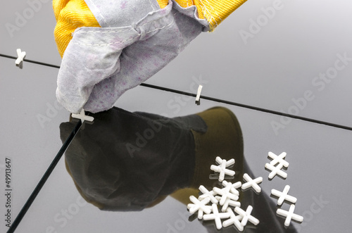 Photo: Tilers hand while installing tiles Tilers hand while installing tiles