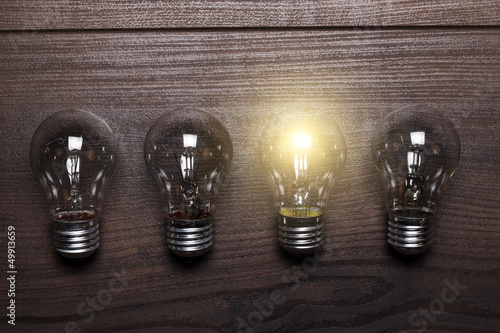 Photo: bulb uniqueness concept on wooden background bulb uniqueness concept on wooden background