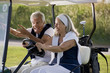 Mature couple riding in golf cart