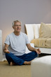 Mature man doing yoga in bedroom