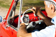 Mature man enjoying a road trip in a small red car