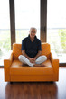Mature man sitting in orange armchair