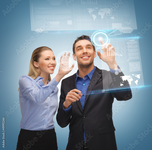 Photo: man and woman working with virtual touch screens man and woman working with virtual touch screens
