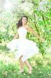 Photo: Beautiful young woman dancing in the morning bright summer orcha Beautiful young woman dancing in the morning bright summer orcha
