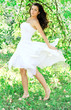 Photo: Beautiful young woman dancing in the morning bright summer orcha Beautiful young woman dancing in the morning bright summer orcha