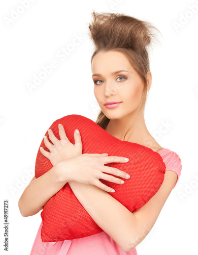 Photo: happy and smiling woman with heart-shaped pillow happy and smiling woman with heart-shaped pillow