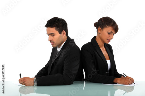 Photo: Business couple writing on forms Business couple writing on forms