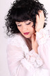 Сurly brunette woman in a white blouse