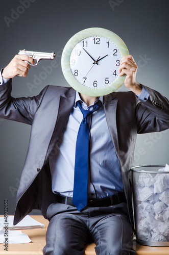 Photo: Man with clock and pile of papers Man with clock and pile of papers