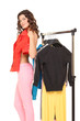 beautiful young girl chooses clothes in a wardrobe with hangers