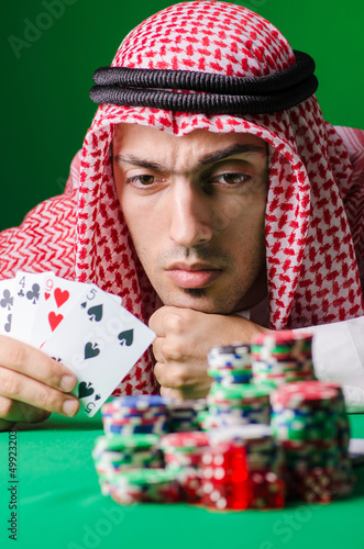 Photo: Arab playing in casino - gambling concept with man Arab playing in casino - gambling concept with man