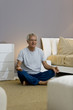 Mature man doing yoga in bedroom