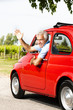 Photo: Mature man enjoying a road trip in a small red car Mature man enjoying a road trip in a small red car