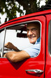 Mature man enjoying a road trip in a small red car