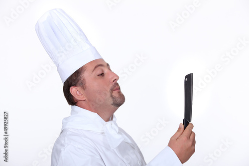 Photo: Chef looking at his reflection in a knife Chef looking at his reflection in a knife