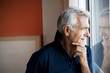 Mature man standing at window