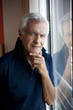 Mature man standing at window