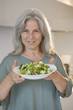Mature woman holding bowl of salad