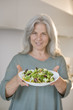 Mature woman holding bowl of salad